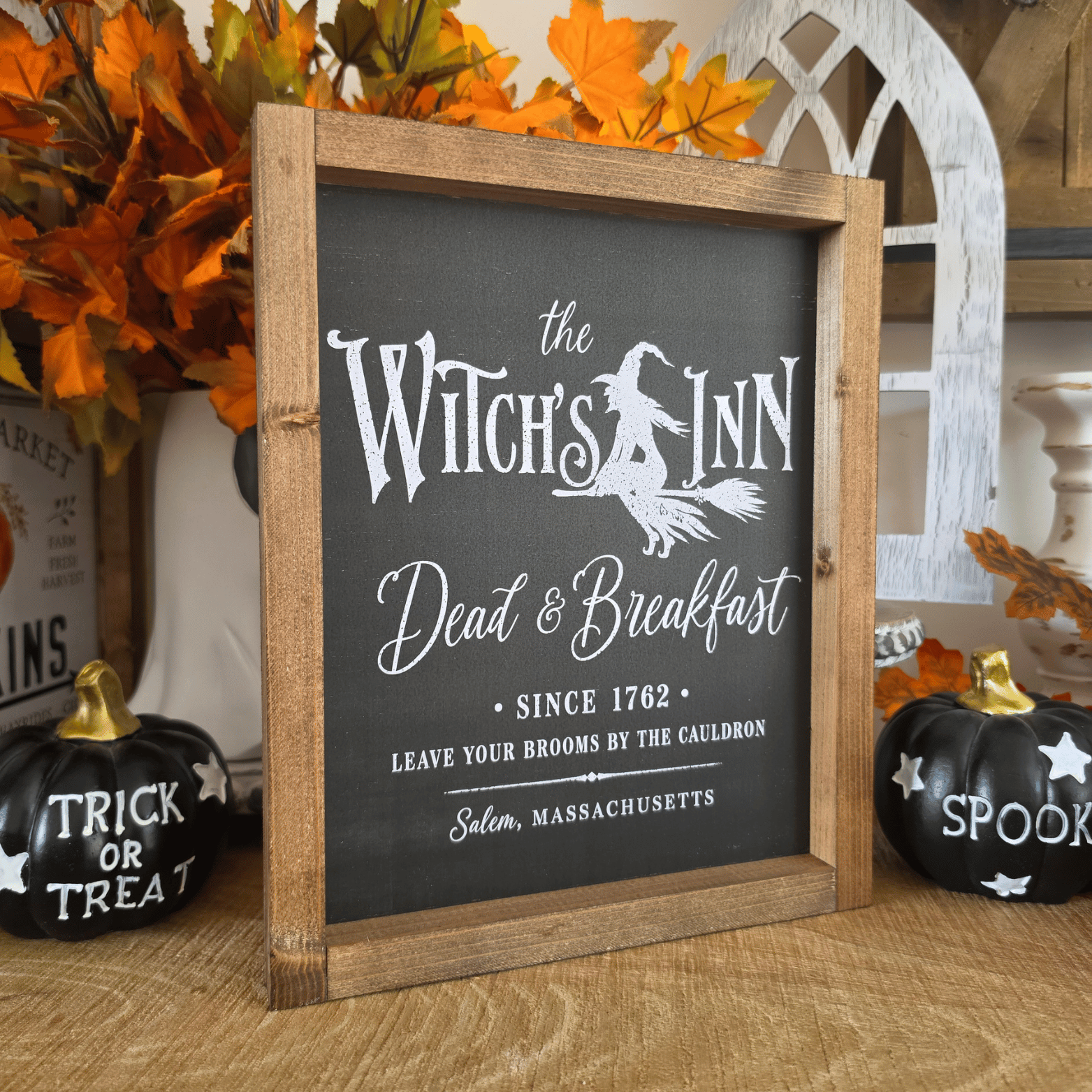 Cadre sign farmhouse The Witch’s Inn noir avec sorcière sur un balai