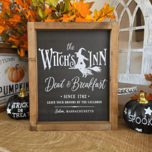 Cadre sign farmhouse The Witch’s Inn noir avec sorcière sur un balai