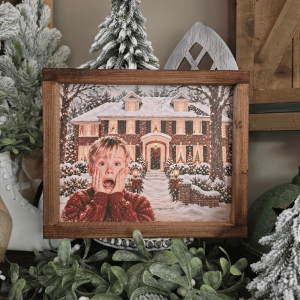 Cadre Noël avec maison enneigée et enfant surpris