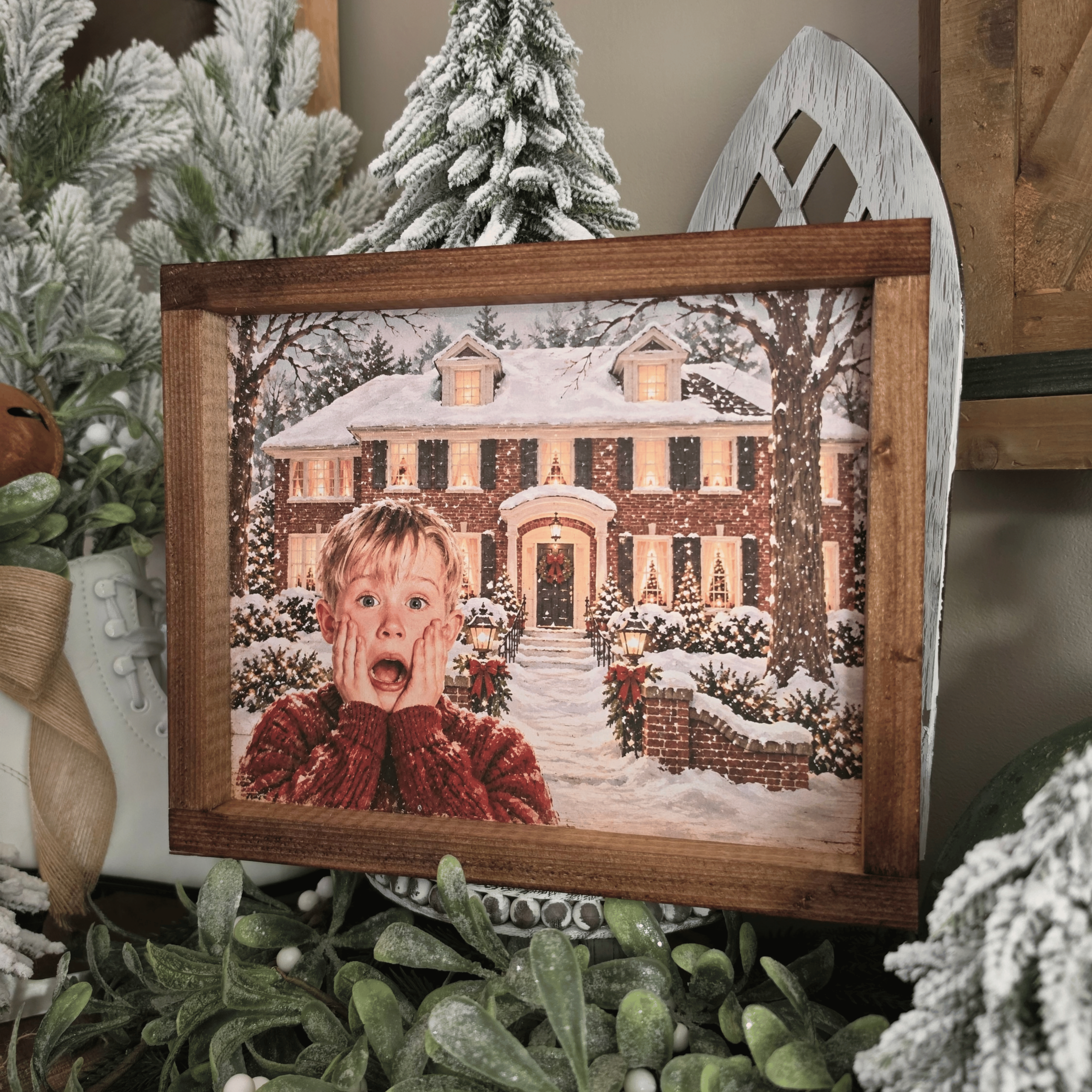 Cadre Noël avec maison enneigée et enfant surpris