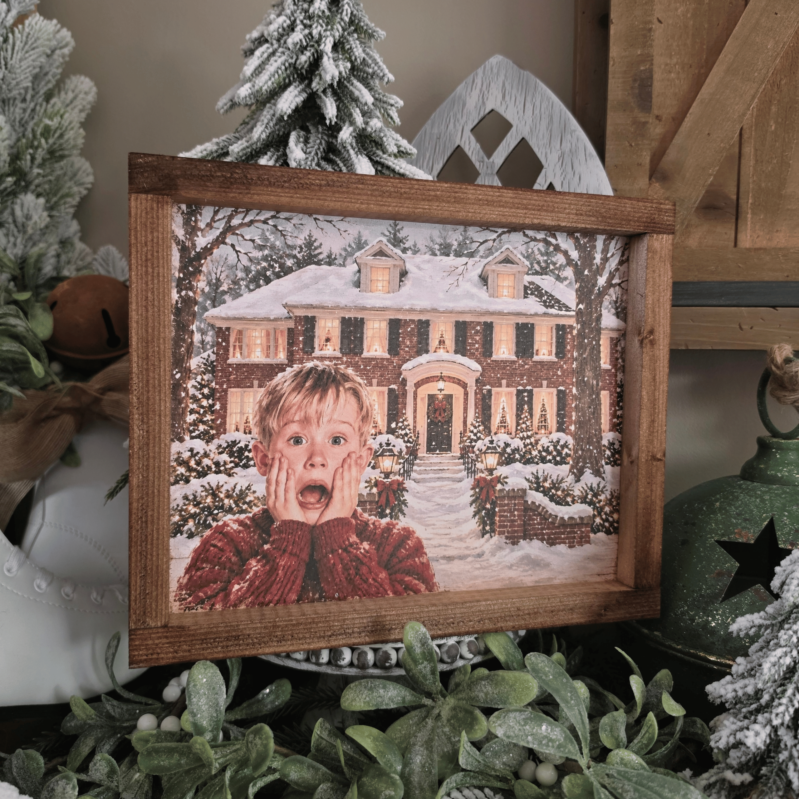 Cadre Noël avec maison enneigée et enfant surpris