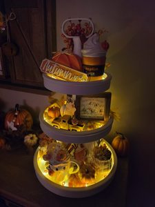 Tiered tray automnal éclairé avec citrouilles, décorations farmhouse et guirlande lumineuse